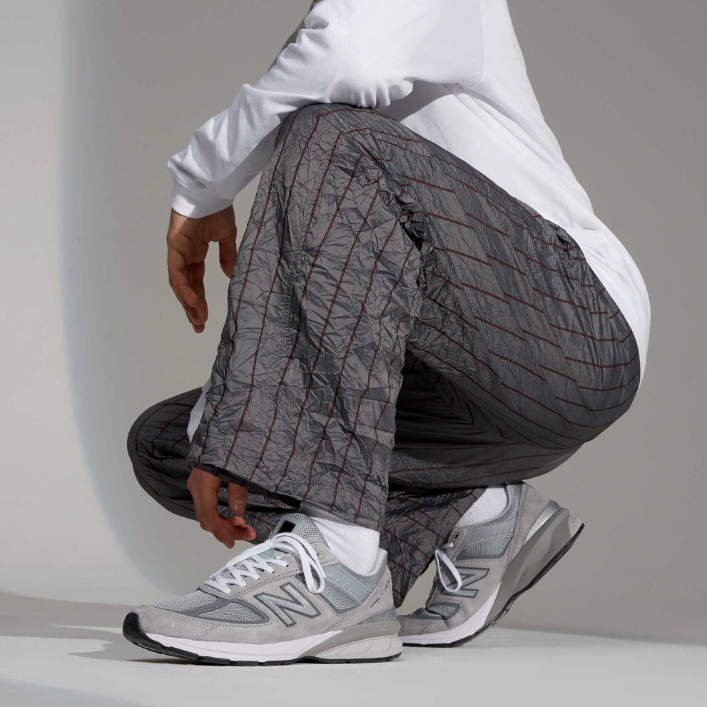 Grey 990 men&rsquo;s sneakers styled with striped grey pants 