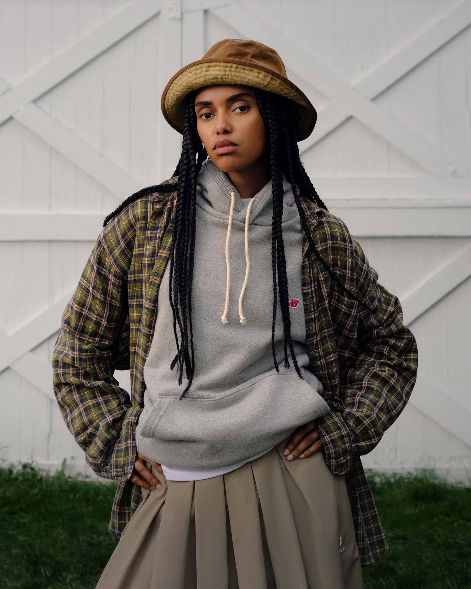 A woman standing against a barn backdrop. 